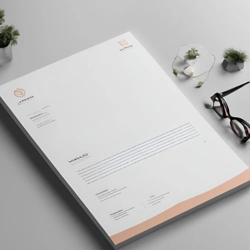  An elegant letterhead design with a pen and glasses positioned on a table, showcasing smart graphics and printing.